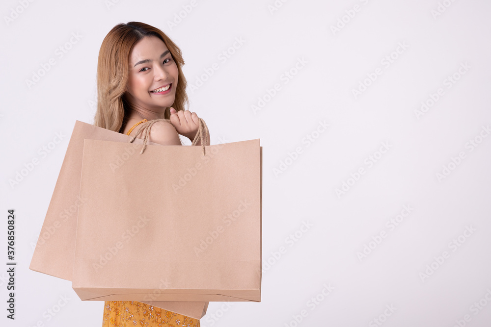 Happy asian woman holding shopping bag with mid year sale. Happy asian woman holding shopping bag with mid year sale.