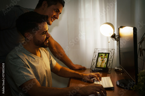 LGBT married caucasian gay couple working at home together