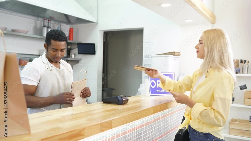 Affable african cafe worker serve clients, give takeaway orders to customers, he is friendly, love his job, prevent coronavirus pandemic, covid-19 Affable african cafe worker serve clients, give takeaway orders to customers, he is friendly, love his job, prevent coronavirus pandemic, covid-19