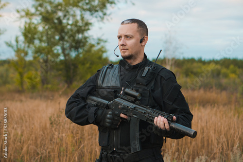 Special force soldier in black uniform with an assault rifle.