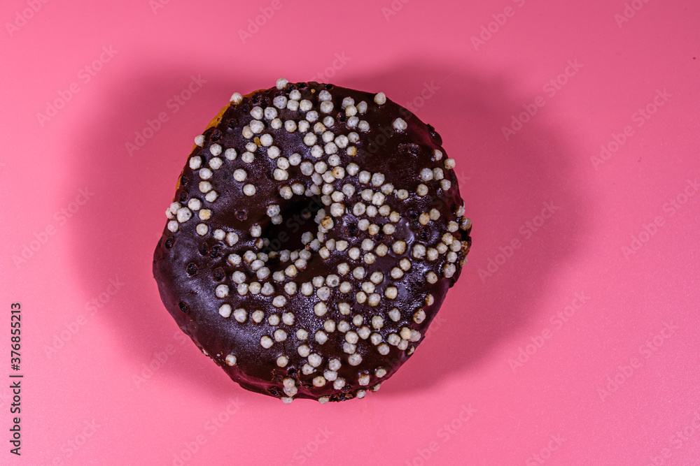 Donut with chocolate glaze on top isolated on a pink background Donut with chocolate glaze on top isolated on a pink background