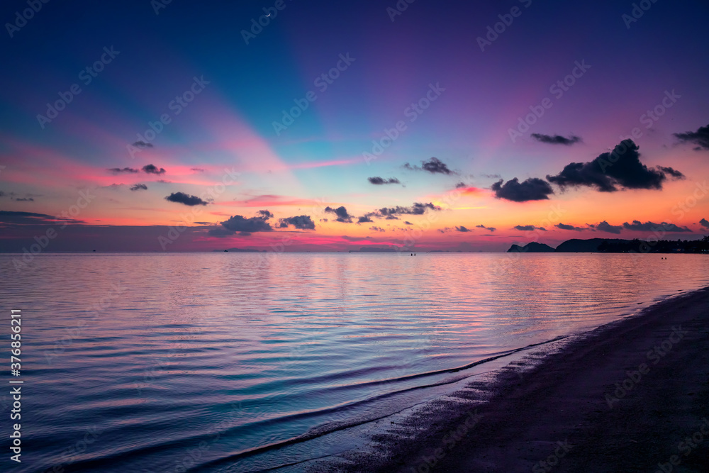 Bright beautiful landscape. Lilac sunset with pink clouds on tropical beach