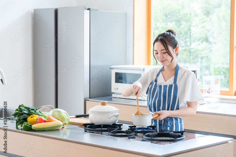 キッチンで料理する若い女性 キッチンで料理する若い女性