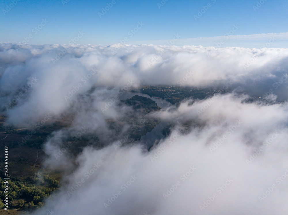 Flight among thick clouds over the Dnieper river in Kiev.