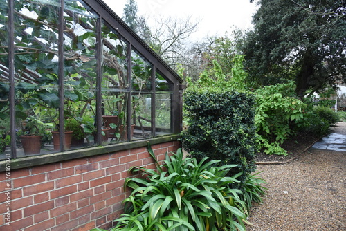 Fotografija Entourage of botanical garden glass greenhouse with plants pots and garden stuff