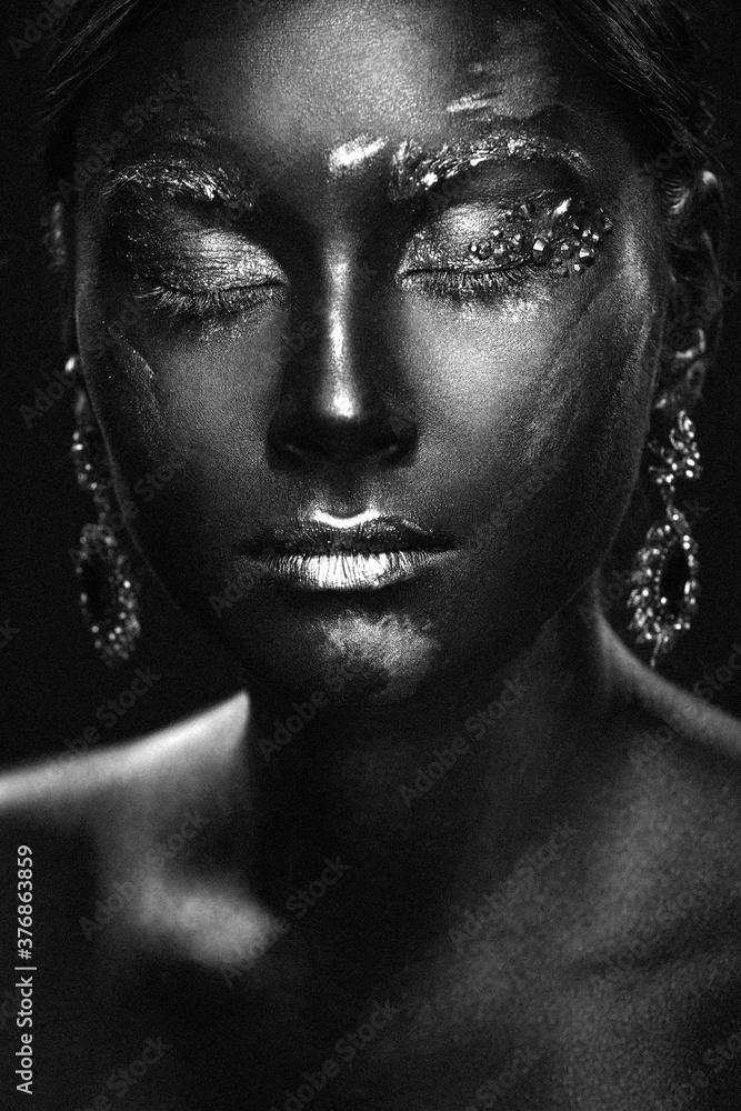 Portrait of a beautiful girl with an exquisite fantasy makeup in the style of legends about ancient greece and the pharaohs in black and white