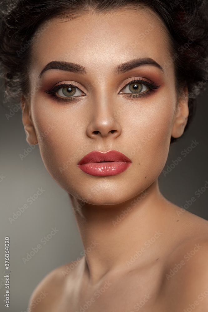 portrait of a beautiful brunette girl with a sophisticated professional visage with full lips and gray-green eyes