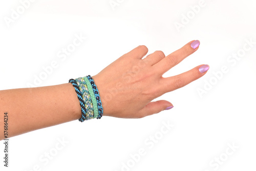 Homemade friendship bracelet on the hand, on the white background.