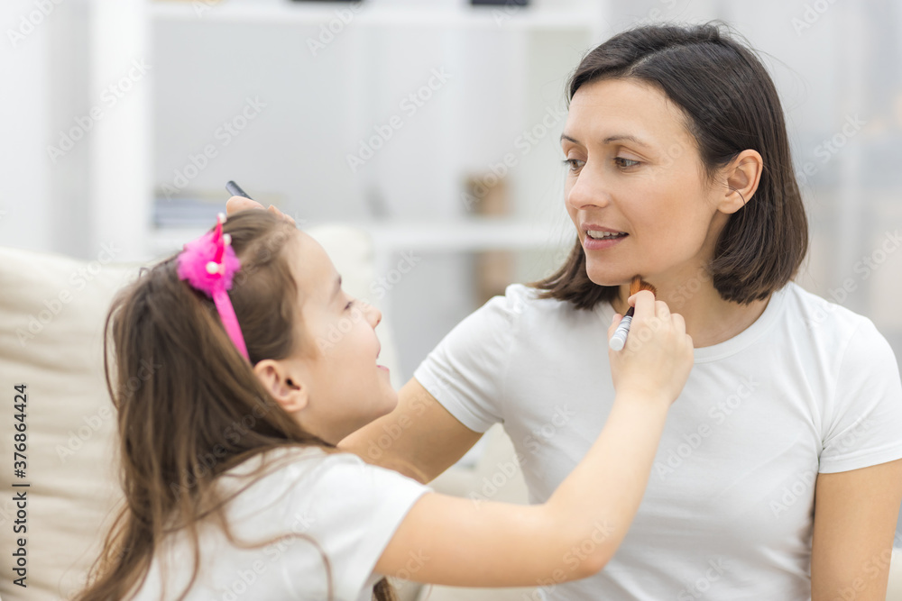 Pretty mother teaching her daughter doing make up at home. Pretty mother teaching her daughter doing make up at home.