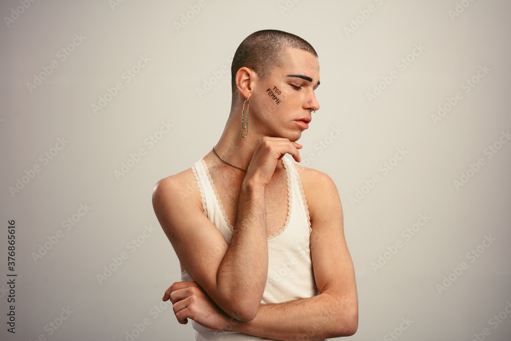 Gender fluid man posing in a tank top and earring Gender fluid man posing in a tank top and earring