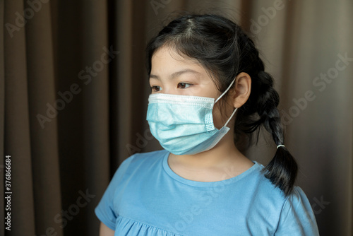 Portrait of Asian young female children young littel cute daughter wear face medical mask. pandemic coronavirus disease quarantine in home. Covid-19 outbreak prevention concept.