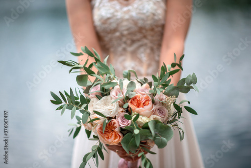 Wedding bouquet of the bride on the background of the lake