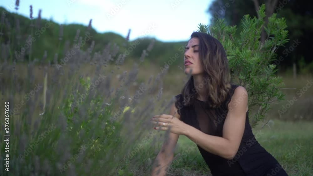 sitting woman smelling a flower in the field sitting woman smelling a flower in the field