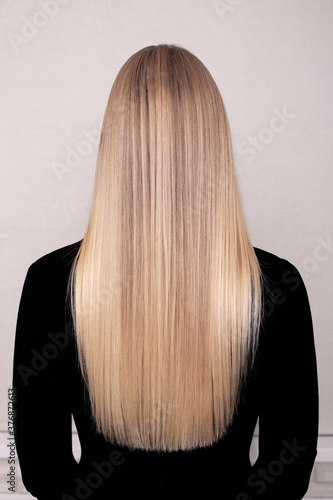 Female back with long straight blonde hair in hairdressing salon photo
