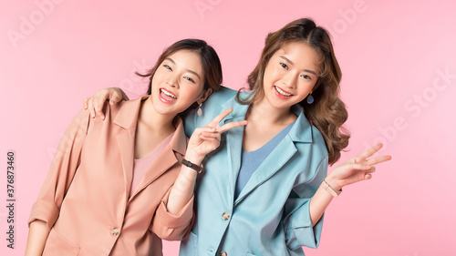 Portrait of two beautiful women friends posing happy gesture