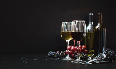 Wine in two wine glasses standing on a dark tabletop