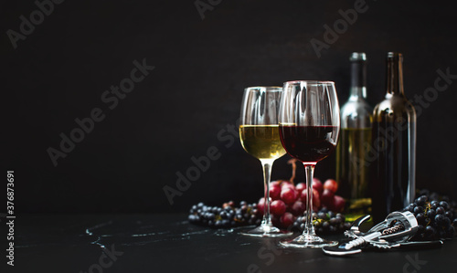 Wine in two wine glasses standing on a dark tabletop