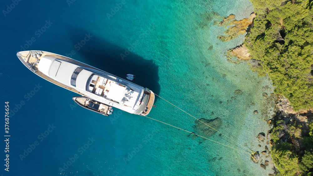 Aerial drone photo of luxury yacht anchored in tropical exotic island bay with turquoise sea