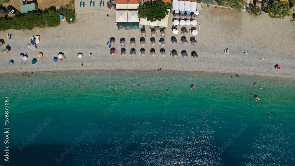 Aerial top down photo of famous organised crystal clear turquoise sandy beach of Panormos, Skopelos isalnd, Sporades, Greece