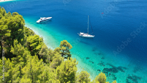 Aerial drone photo of yacht anchored in famous crystal clear bay and turquoise beach of Panormos, Skopelos island, Sporades, Greece photo