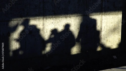 Shadows of the people on a concrete wall in slow motion
