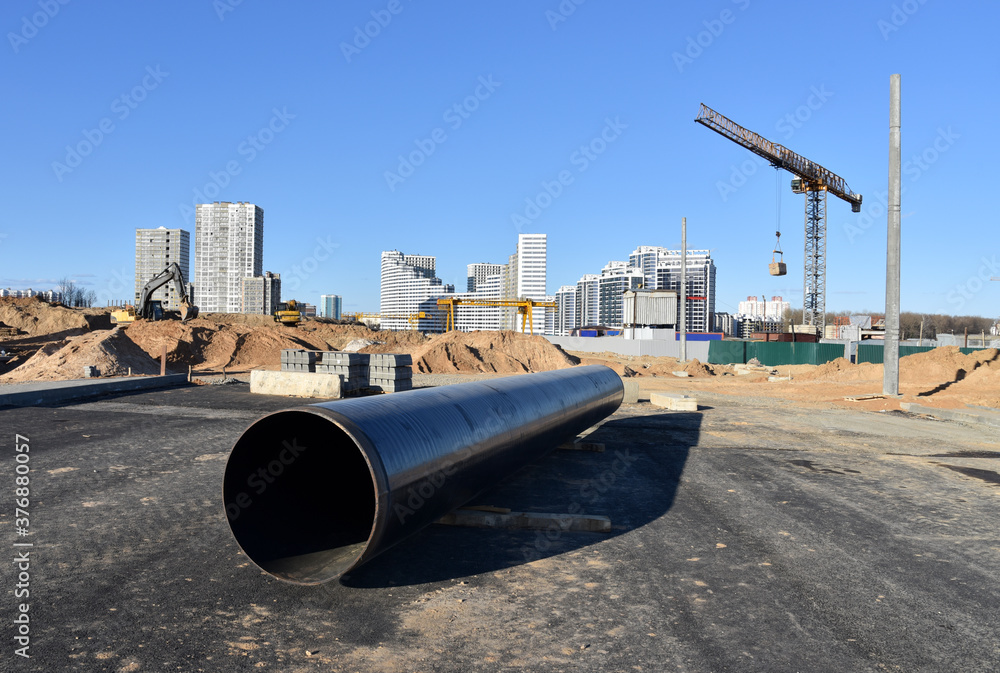 Fototapeta premium Black pipe at construction site for sewerage. Water main sanitary drainage system. Civil infrastructure pipe, water lines and storm sewers