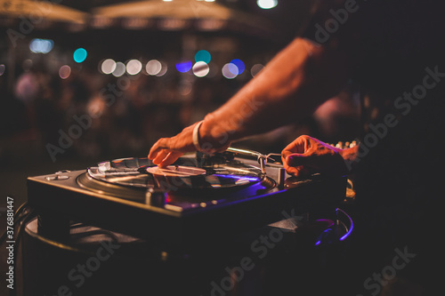 Dettaglio di disk jockey che suona durante un evento serale di un locale estivo all'aperto photo