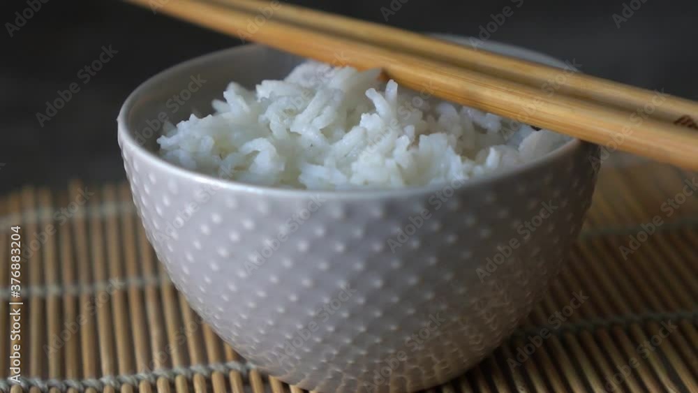 Rice in a porcelain bowl, with Japanese chopsticks, soy sauce, served on a gray stone table Close up Rice in a porcelain bowl, with Japanese chopsticks, soy sauce, served on a gray stone table Close up
