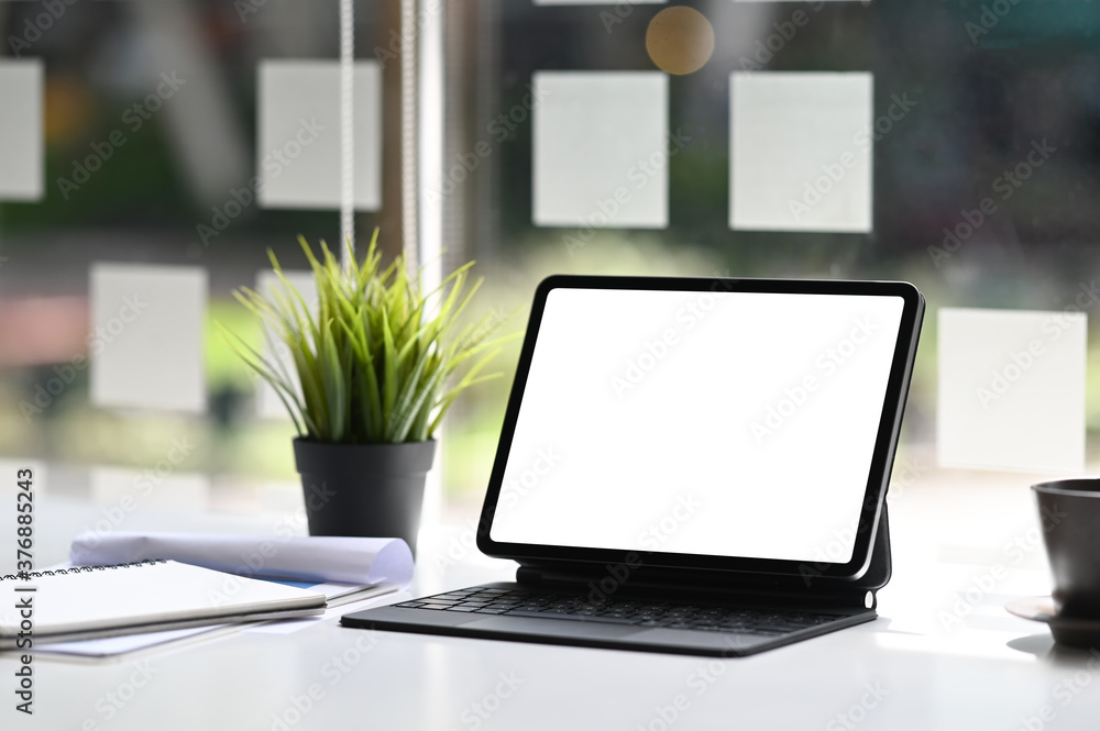 Office desk with mock up tablet with blank sccreen and supplies on white table at modle office. Office desk with mock up tablet with blank sccreen and supplies on white table at modle office.