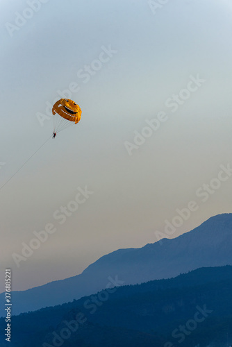 Smiling Parashute, Parasailing against the background of the mountain ridge near Kemer, in Turkey.