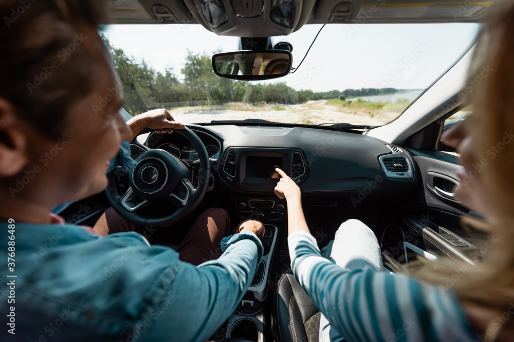 Obraz premium Selective focus of woman pointing with finger while husband driving car