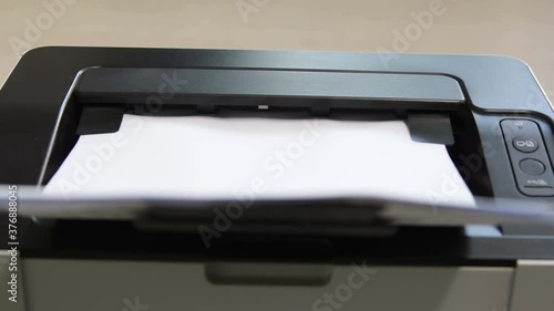 Laser printer operation. Closeup of paper printing.