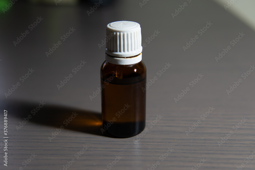 Medicine liquid container with white lid and brown glass. It contains a liquid inside. Medicine liquid container with white lid and brown glass. It contains a liquid inside.