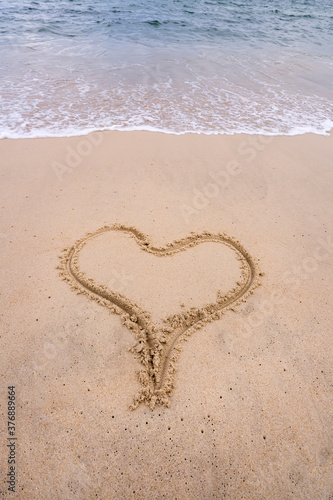 heart drawn in the sand on the beach. Romantic design element.