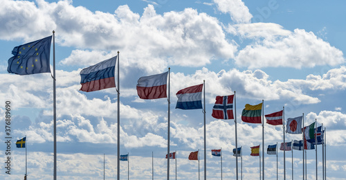 Flags of the world with clouds in the background.