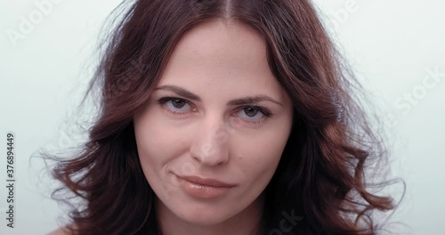 Woman looks at the camera with reproach and laughs. She's making mock. Looks contemptuous. High quality 4k footage. 