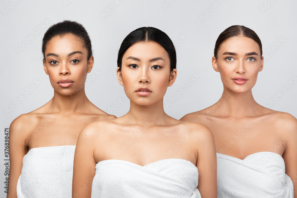 Three Diverse Girls Wrapped In Bath Towels Standing In Studio Three Diverse Girls Wrapped In Bath Towels Standing In Studio