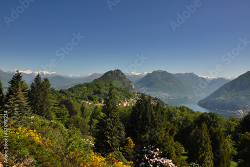 Panoramic View over Landscape with Snow-capped Mountain and Green Trees with an Alpine Lake Lugano in Ticino, Switzerland.