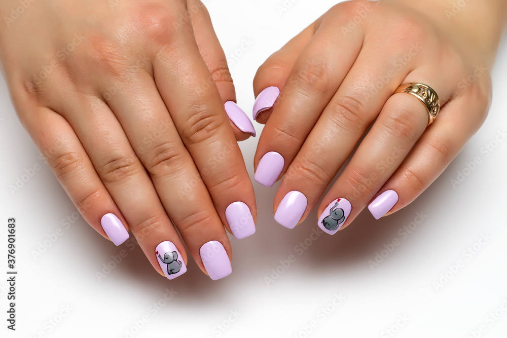 Gel nails. Close up of gray manicure with painted gray elephants and a red heart on short square nails on a white background. Gel nails. Close up of gray manicure with painted gray elephants and a red heart on short square nails on a white background.