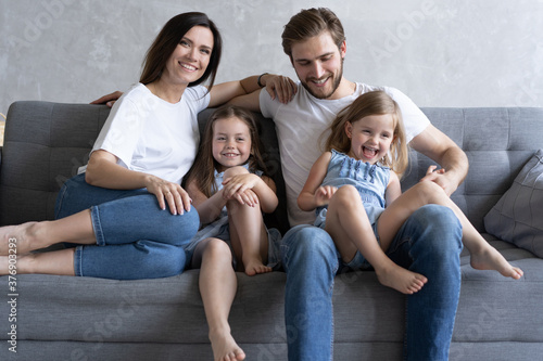 Cheerful family at home sitting in sofa © opolja