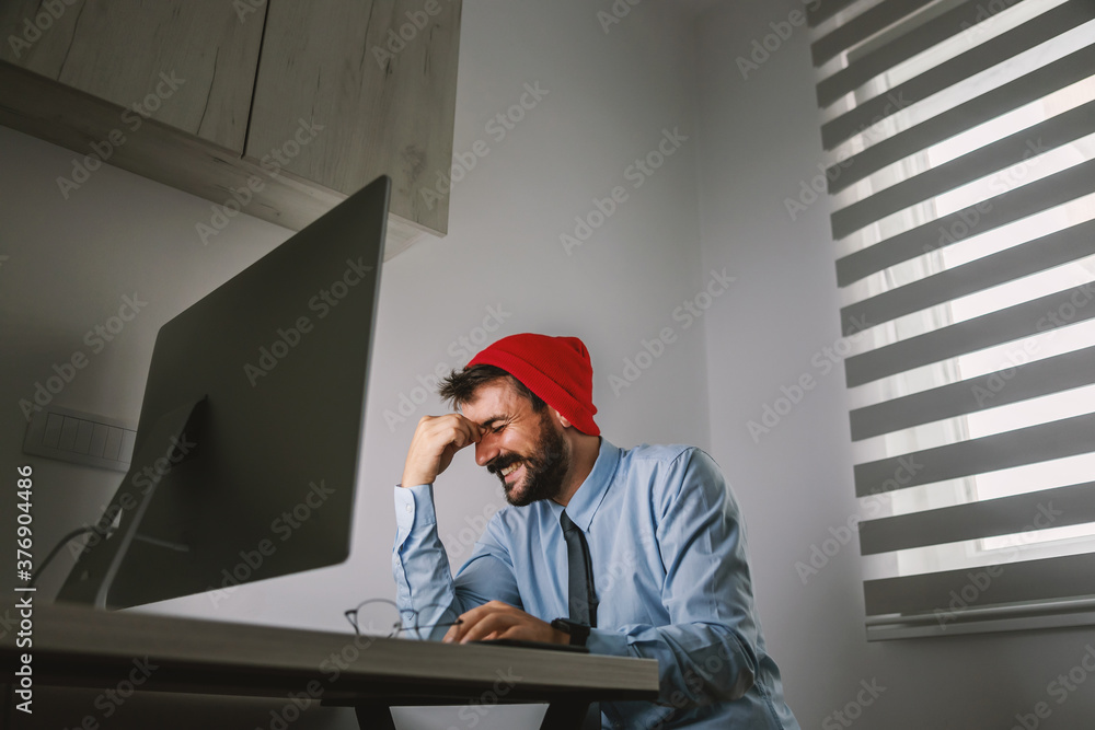 Fototapeta premium Young smiling attractive businessman dressed business casual sitting in his office and working.
