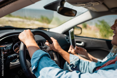 Selective focus of man driving car near wife with digital tablet © LIGHTFIELD STUDIOS