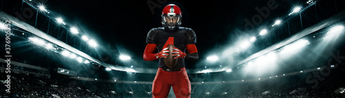 American football player, athlete sportsman in red helmet on stadium background. Sport and motivation wallpaper. Wide photo.