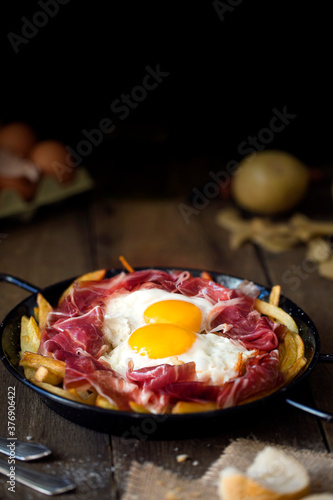 Baroque still life with broken egg casserole with serrano ham photo