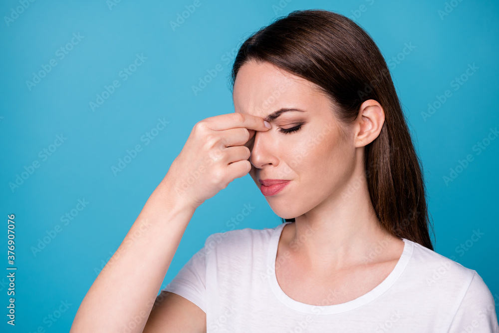 Close up photo of frustrated girl touch fingers nose suffer fever cold have covid symptom wear style stylish trendy clothes isolated over blue color background Close up photo of frustrated girl touch fingers nose suffer fever cold have covid symptom wear style stylish trendy clothes isolated over blue color background