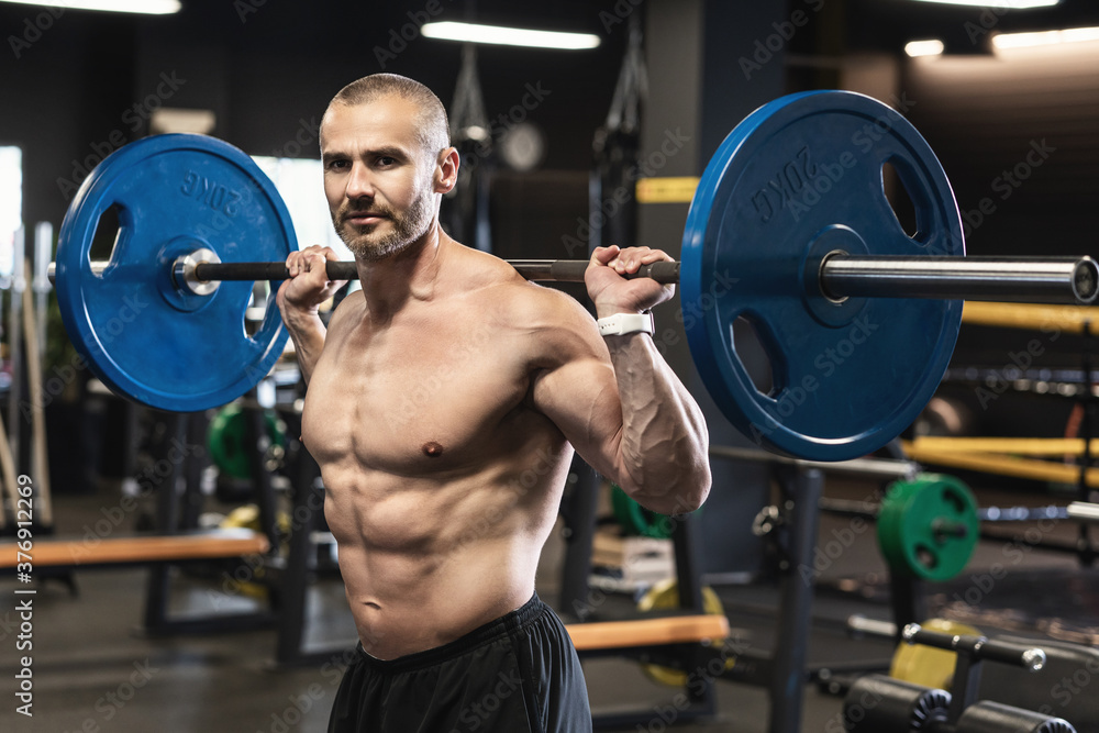 Bodybuilder during his workout with a barbell in the gym Bodybuilder during his workout with a barbell in the gym
