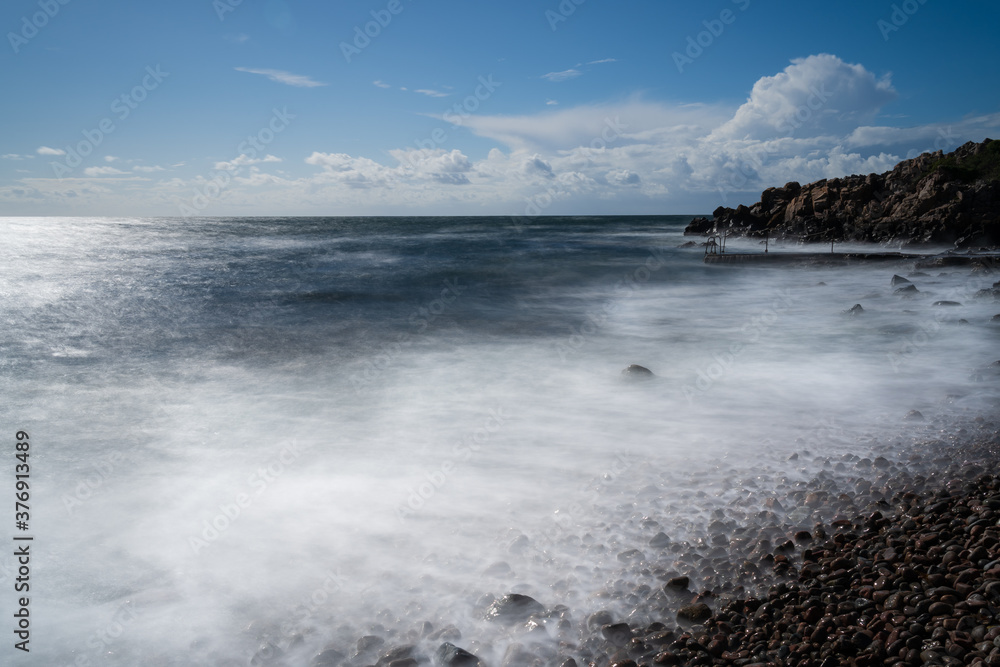 Fototapeta premium Long exposure rocky beach on a sunny autumn day in south Sweden. 