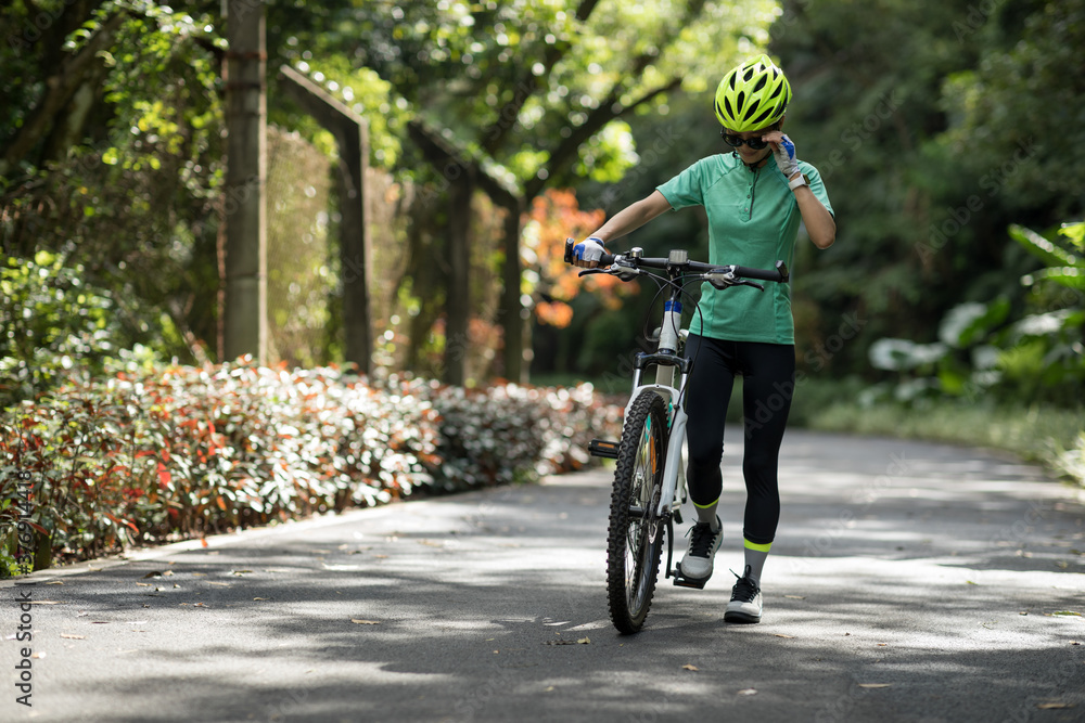Obraz premium Woman riding on bike path at park on sunny day