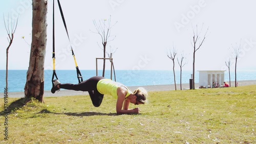 A young woman is practicing with TRX loops on a sunny day29 photo