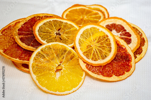 Organic homemade dried orange and grapefruit chips slices on light background